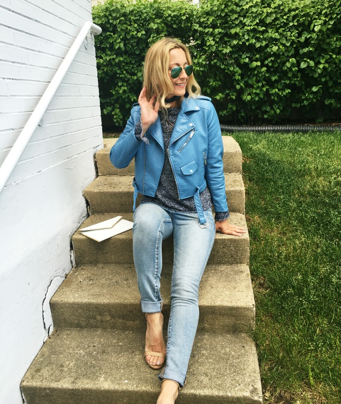woman sitting on the stairs and wearing Blue sweater and leather jacket woman sitting on the stairs and wearing Blue sweater and leather jacket