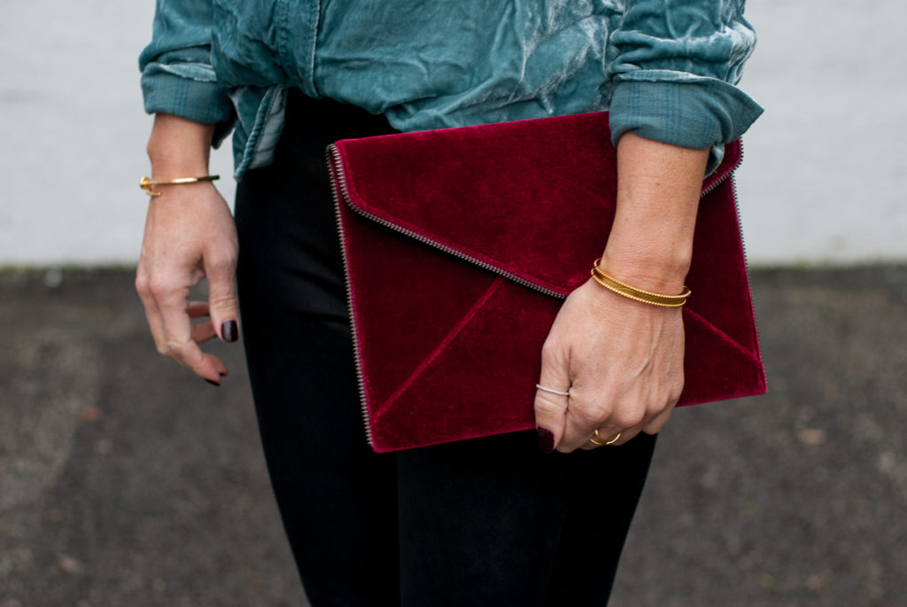 woman holding a red velvet pouch from Black Friday sales woman holding a red velvet pouch from Black Friday sales