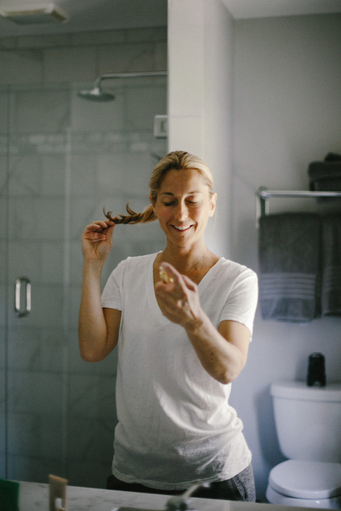 woman spraying beauty product on her face woman spraying beauty product on her face