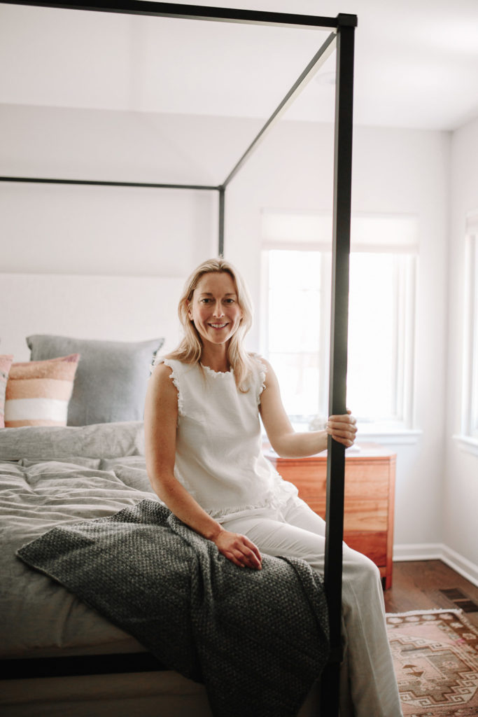 woman sitting on the corner of a bed woman sitting on the corner of a bed