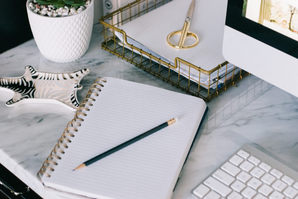 woman sharing blogging goals with a note book and office items on a table 