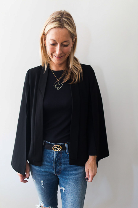 woman posing woman wearing Black cape with arm holes elevates a basic look