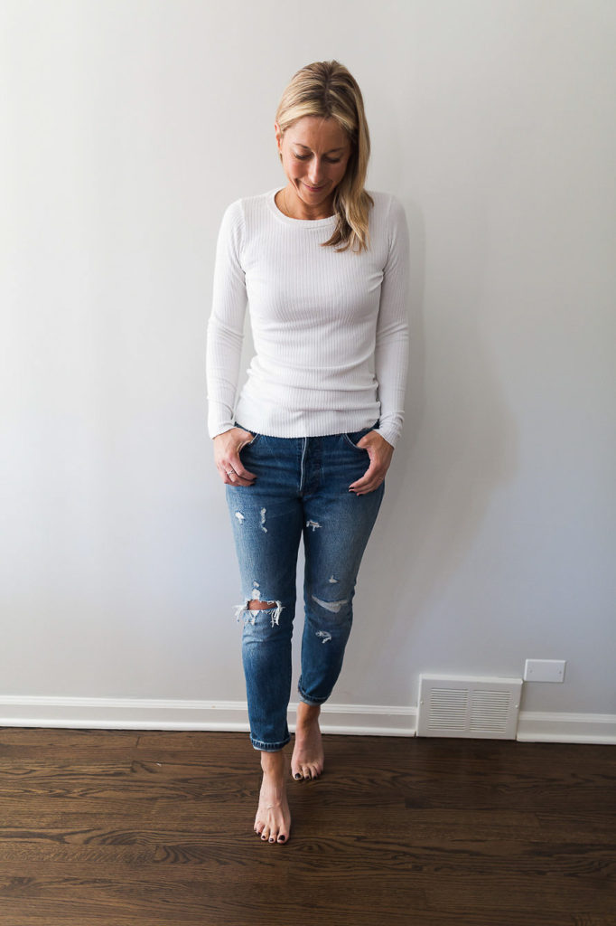 woman wearing white top and jeans woman wearing Denim and a long sleeve white ribbed top