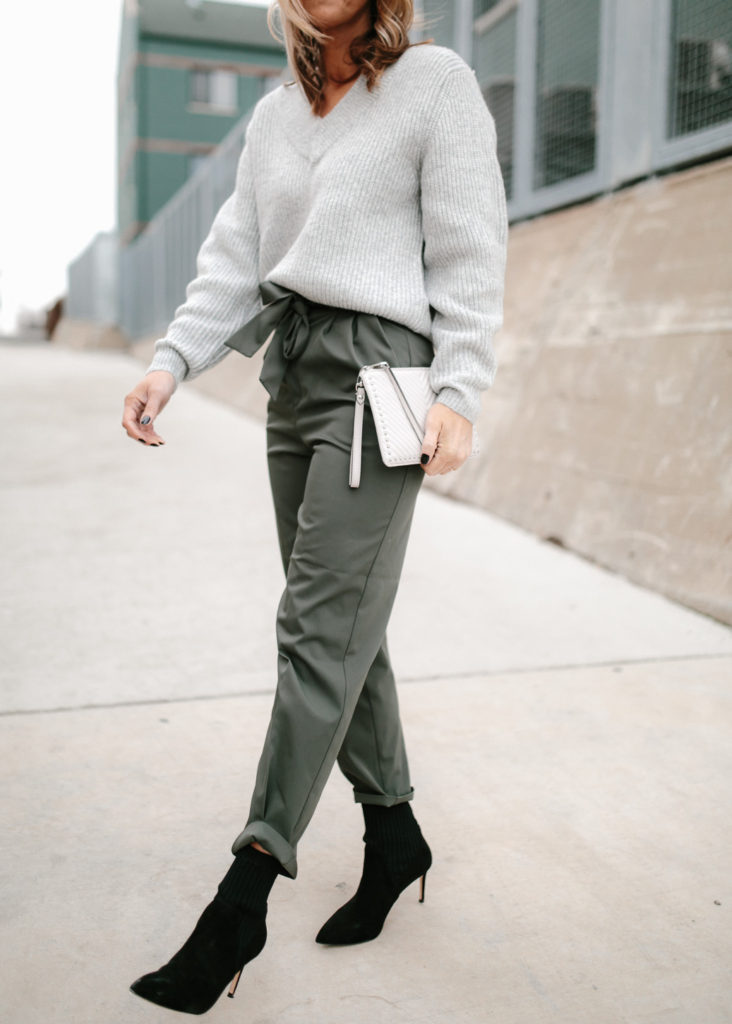 woman posing woman wearing paper-bag pant, sweater, and black boots