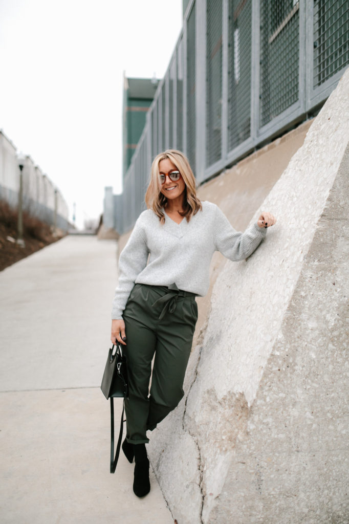Paper bag pant in olive green with grey chunky knit sweater, black sock booties and a black structured bag