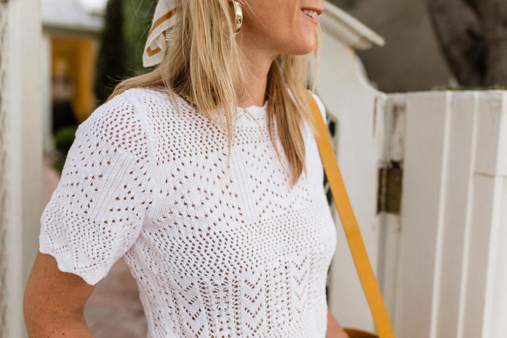 White eyelet top accessorized with gold hoop earrings and a head scarf White eyelet top accessorized with gold hoop earrings and a head scarf