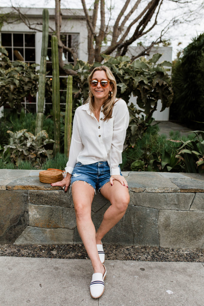 woman wearing denim shorts and White Essentials for Spring woman wearing denim shorts and White Essentials for Spring
