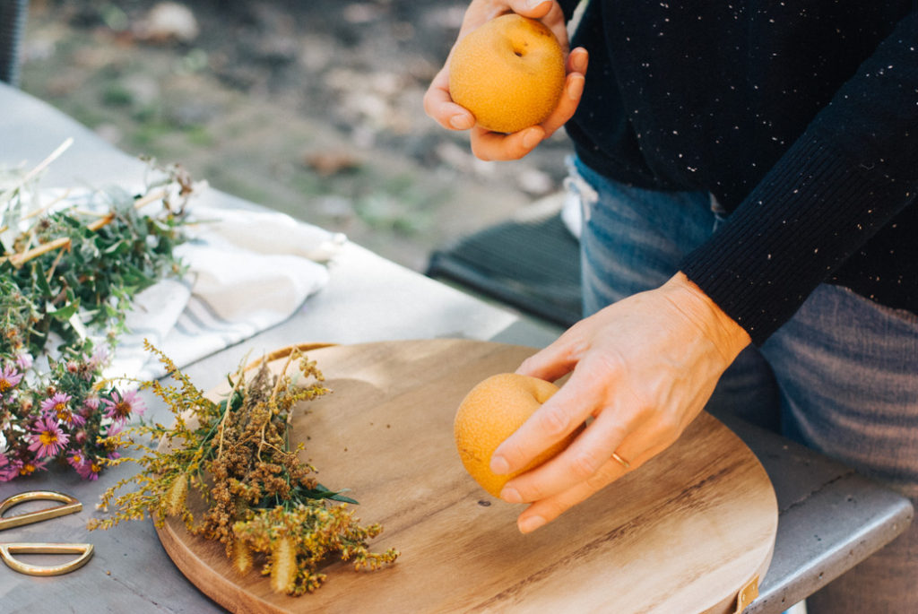 Once your flowers are arranged, add some seasonal fruit to your display. Pears, pomegranates and apples are all great options for this time of year.