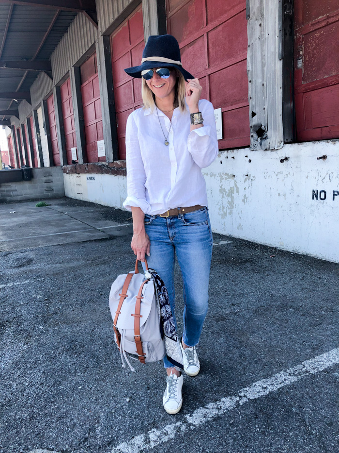 Megan Medica is wearing a white button-down, jeans and sneakers