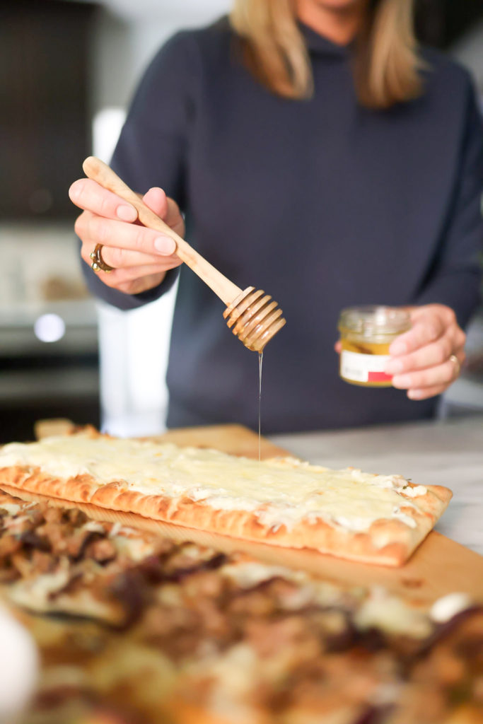 person adding honey on flatbreads person adding honey on flatbreads