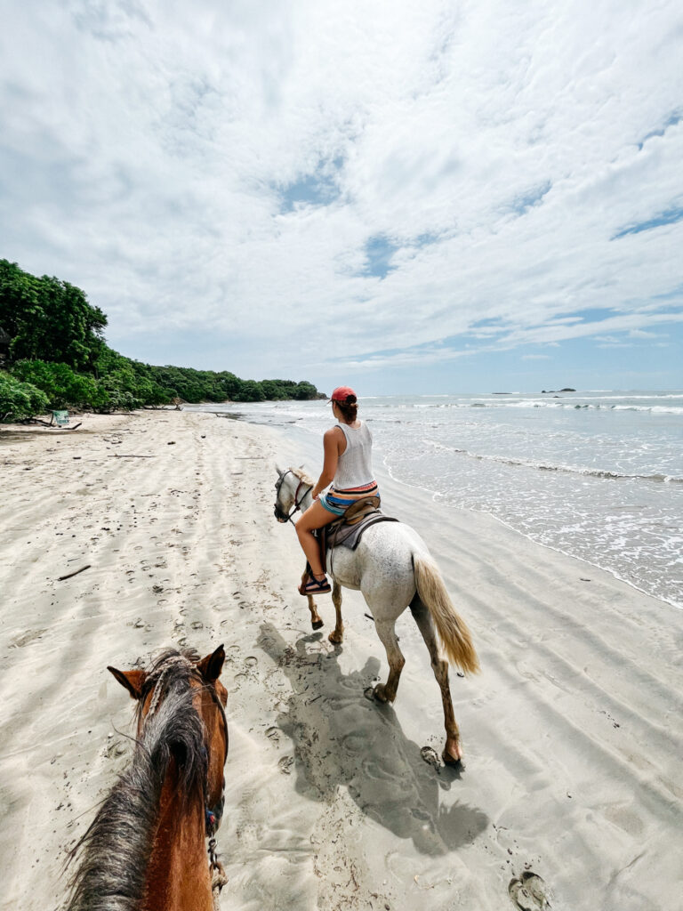 person riding a horse in a shore in a costa rica person riding a horse in a shore in a costa rica
